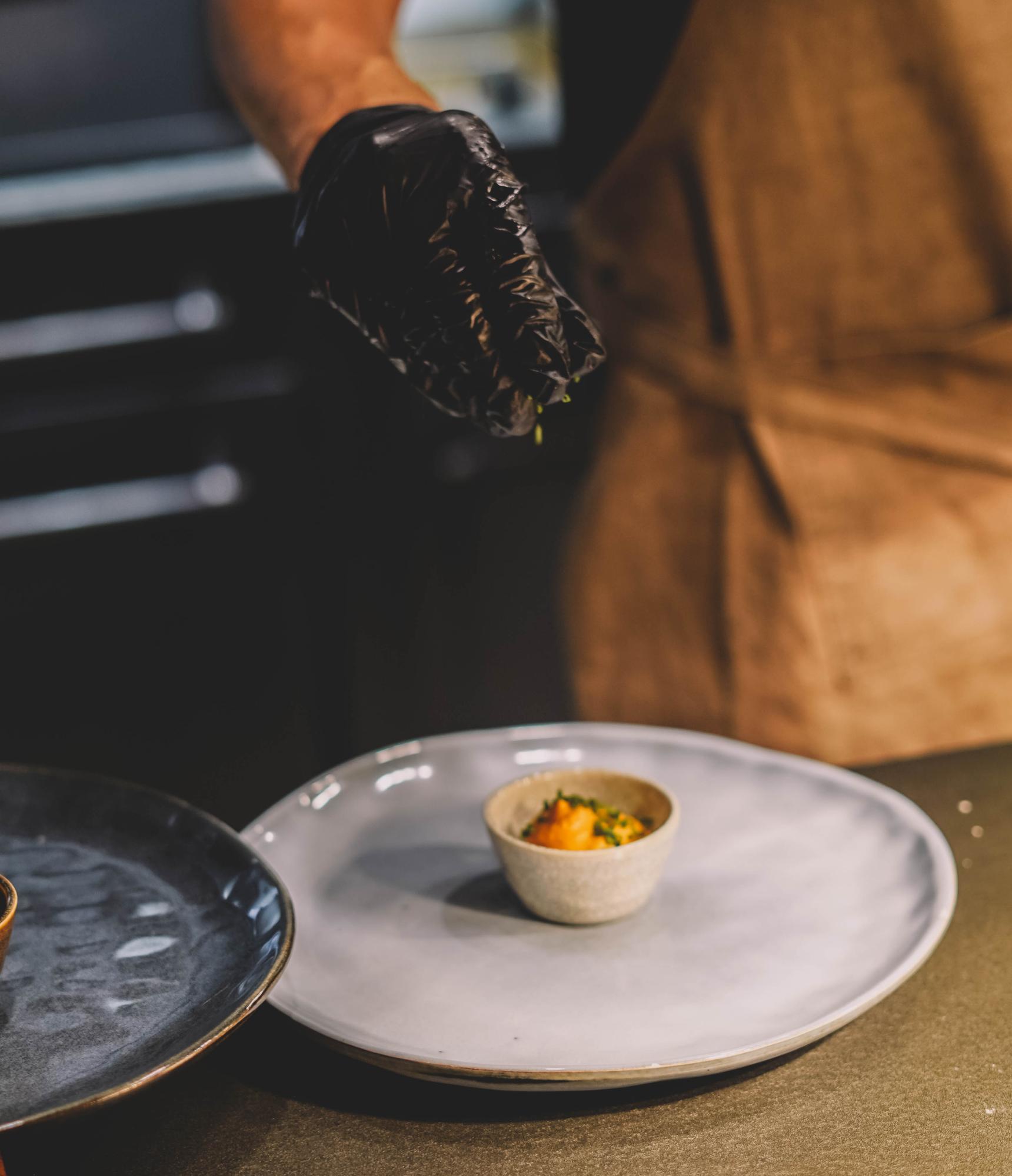 Chef preparing plated dish in a studio kitchen